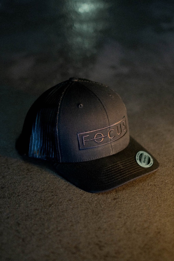 Black cap with 'FOCUS' logo on a textured surface