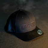 Black cap with 'FOCUS' logo on a textured surface