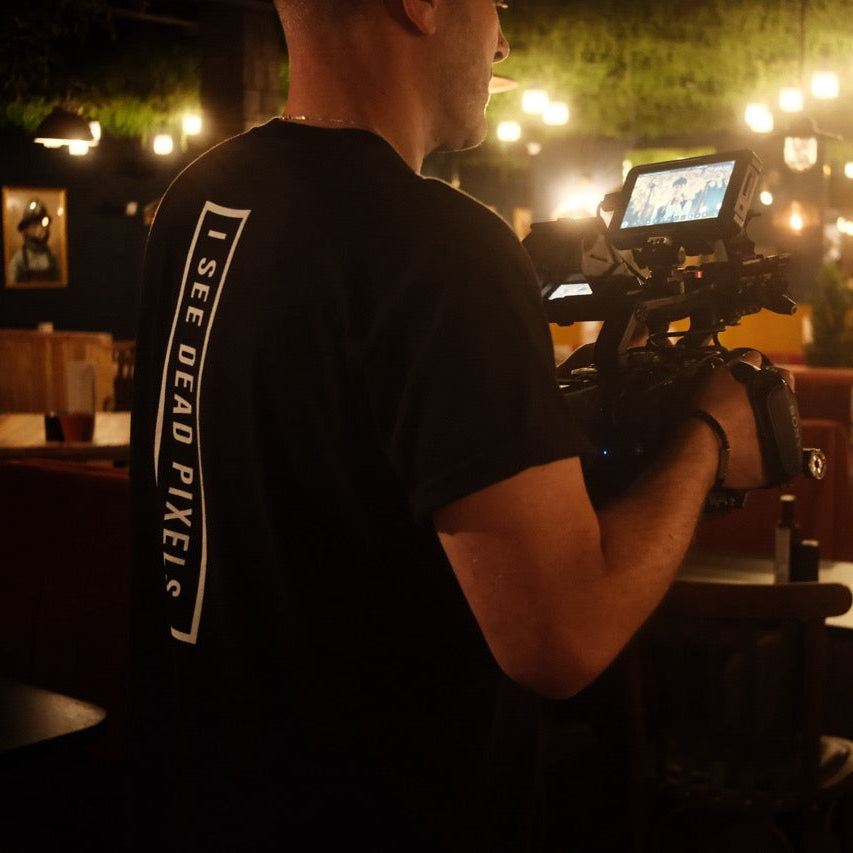 Person holding a camera in a dimly lit restaurant setting